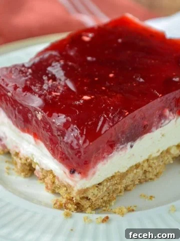 A slice of a three layer dessert with a pretzel base.