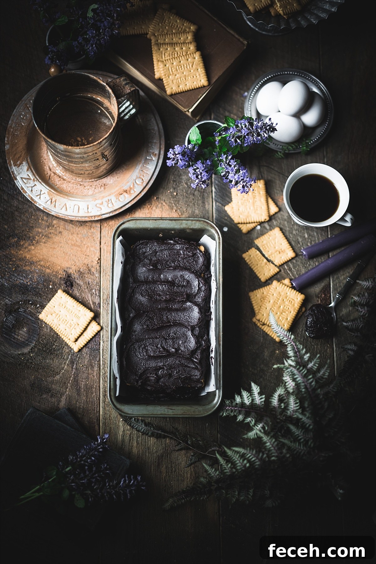 Kalter Hund Recipe: Authentic German No-Bake Chocolate Biscuit Cake 8 An overhead shot of a Kalter Hund no bake cake ready to put in fridge surrounded by Leibniz cookies and other ingredients from the cake.