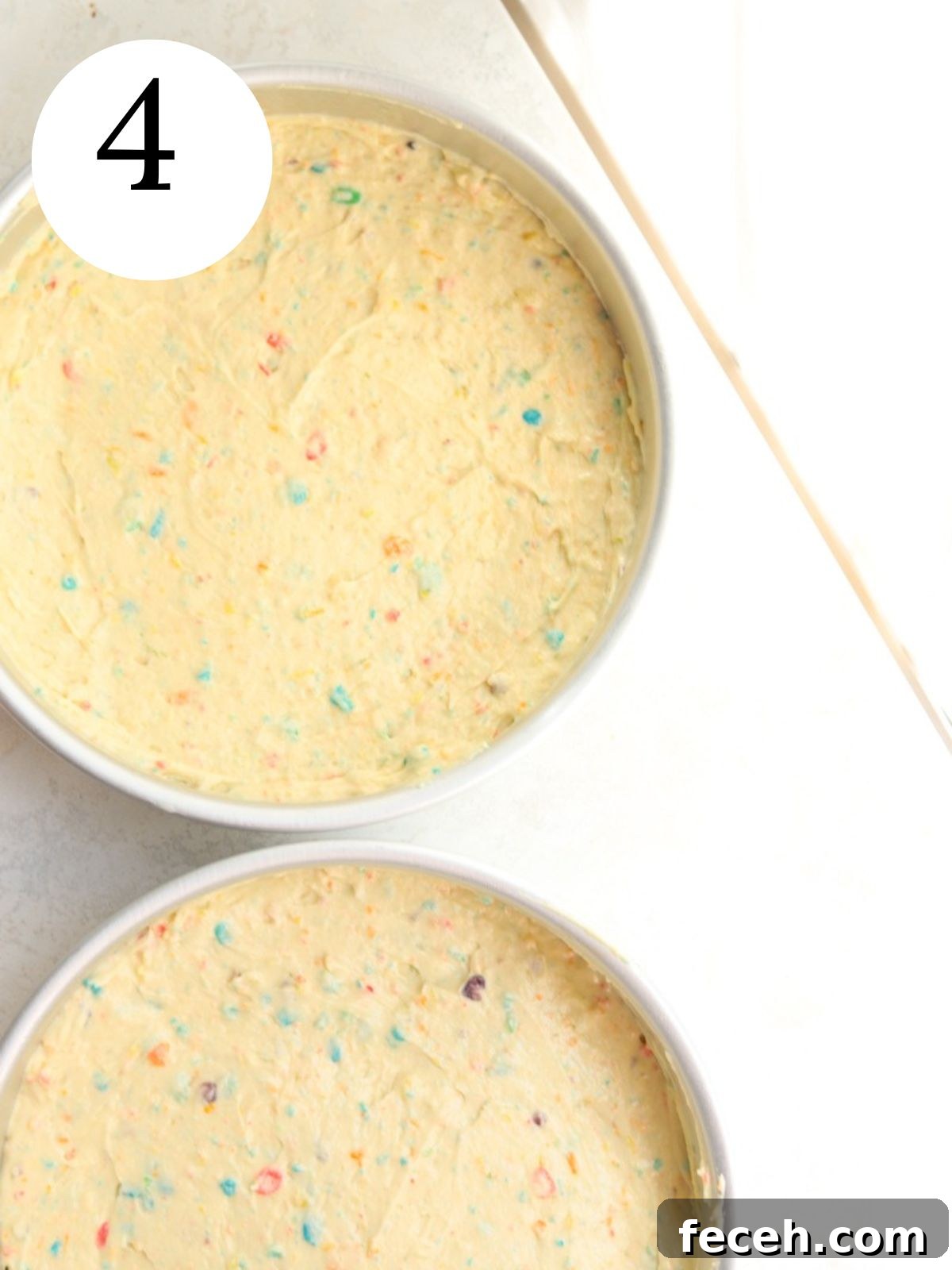 Fruity Pebbles cake batter in two round cake pans.