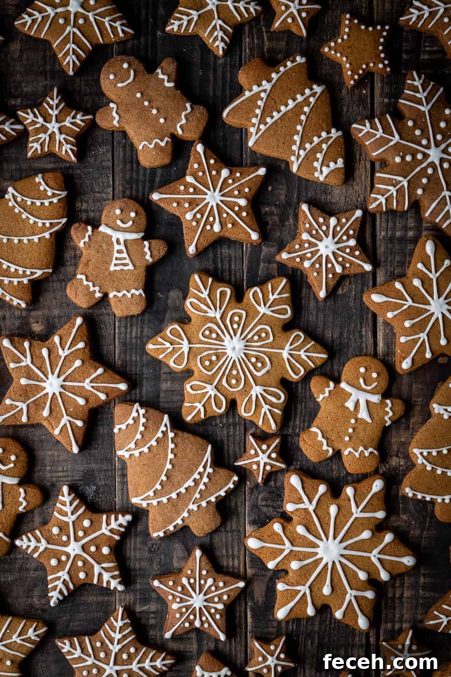 iced vegan gingerbread cookies on a dark wood background.