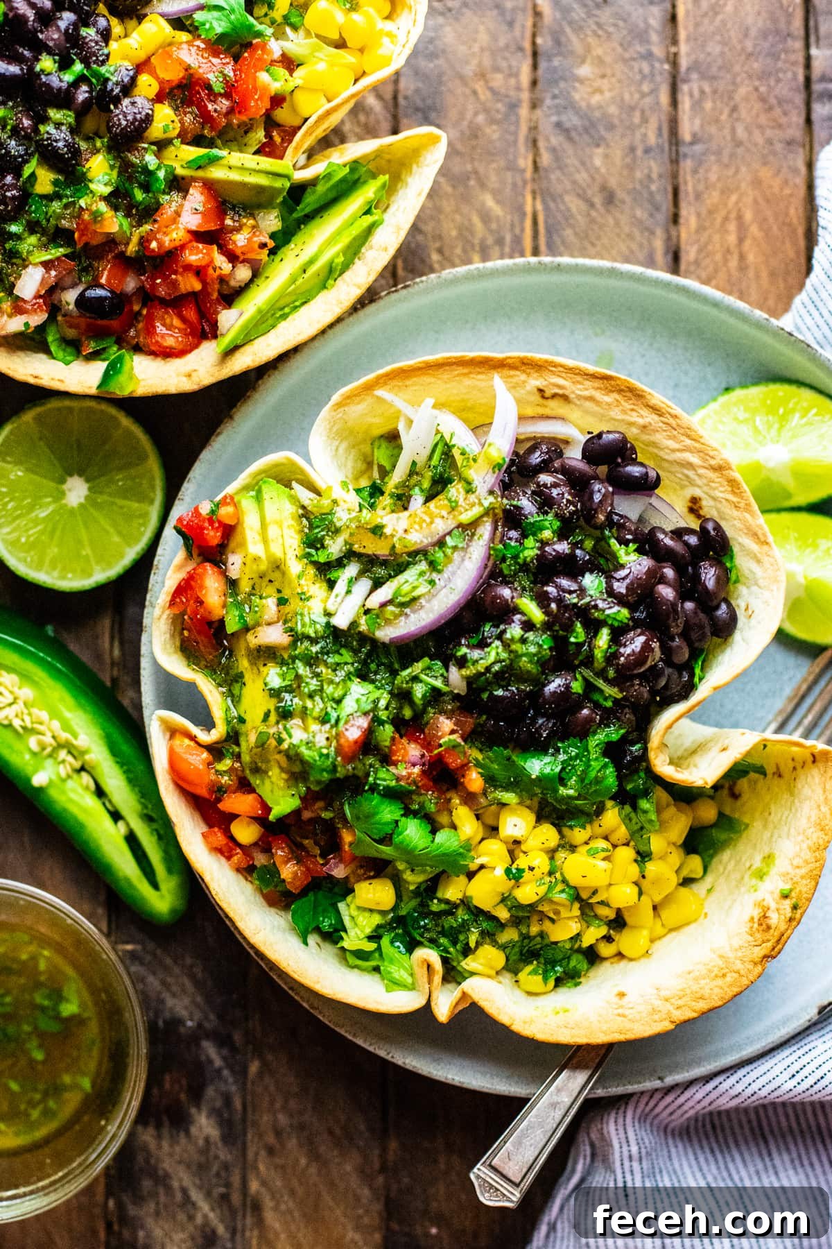 Vegetarian Taco Salad with Cilantro-Lime Dressing Recipe 2 Condiments surrounding a tortilla bowl filled with vegetable taco salad.