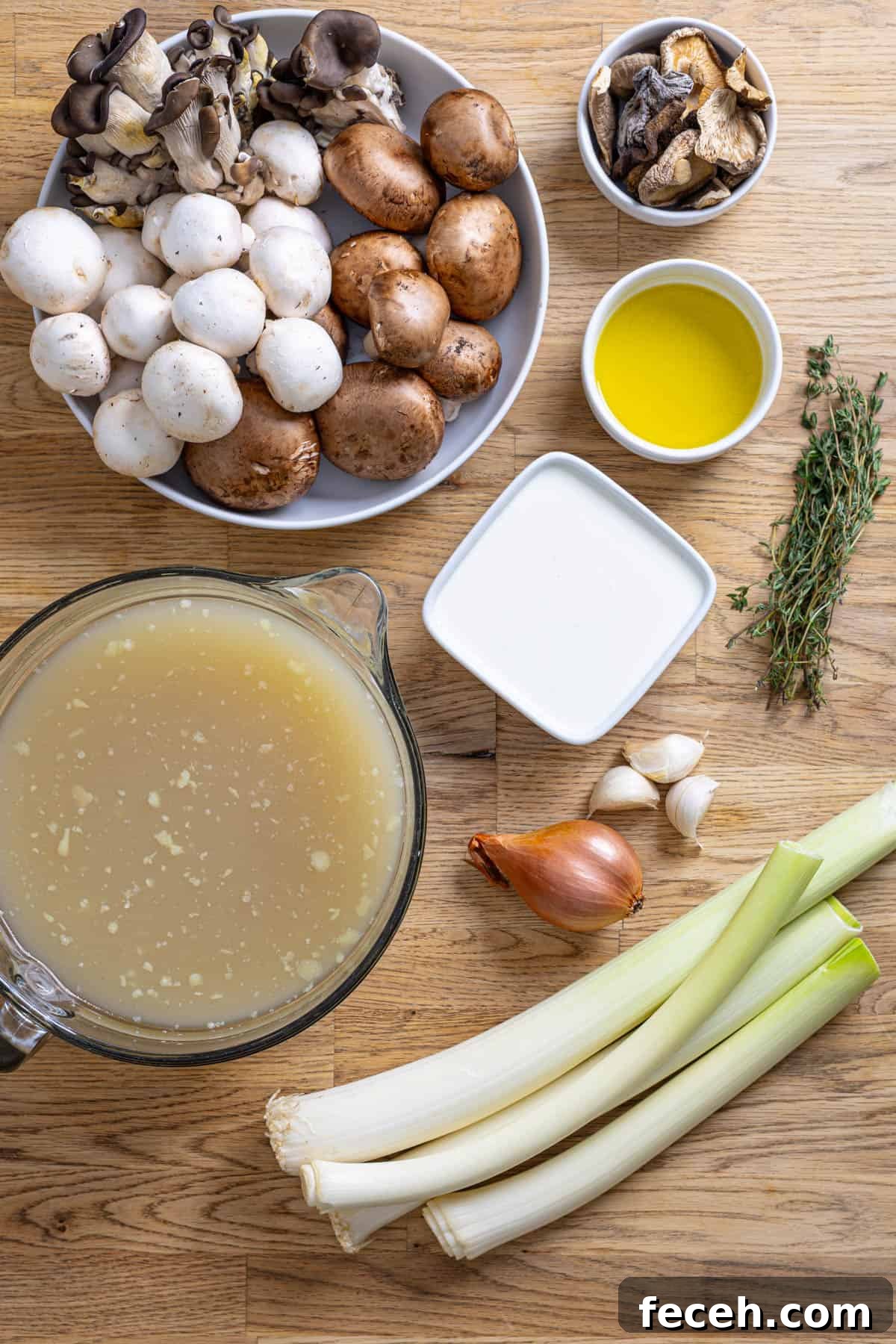 Ingredients for mushroom leek soup on a butcherblock countertop.