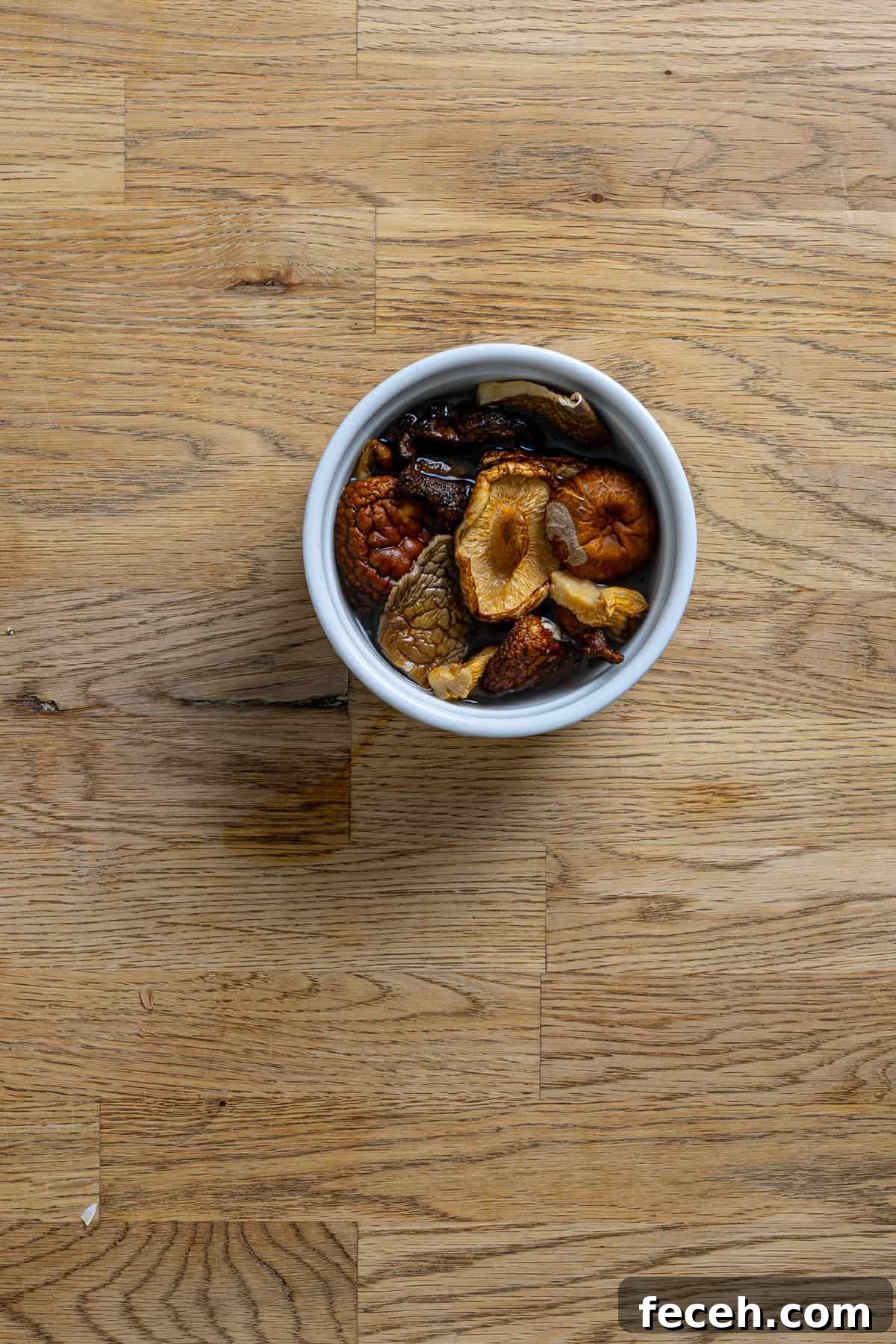 A small bowl with dried mushrooms covered in warm water.