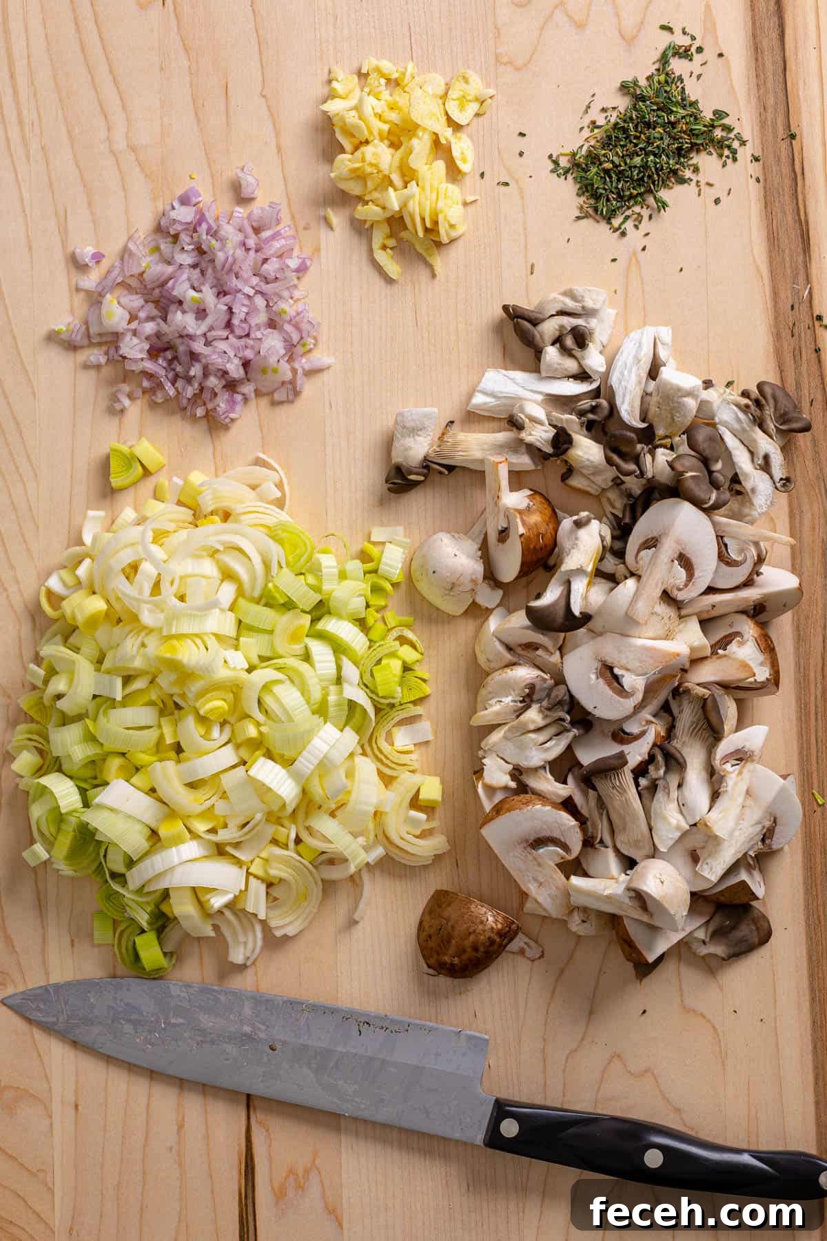 A cutting board with ingredients prepped for mushroom and leek soup.