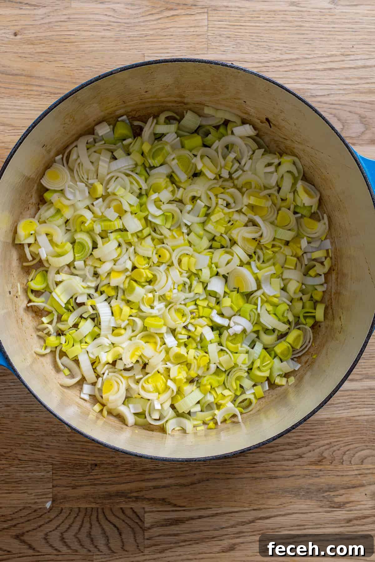 Chopped leeks cooking in a dutch oven.