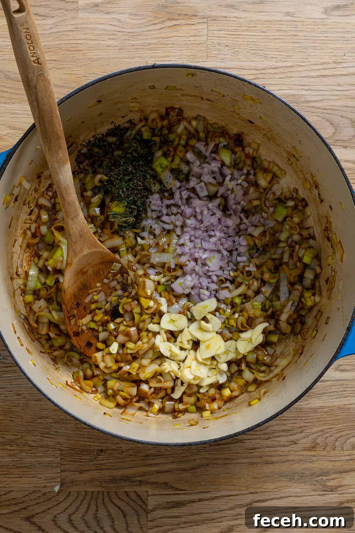 Aromatics added to a dutch oven with leeks cooking.