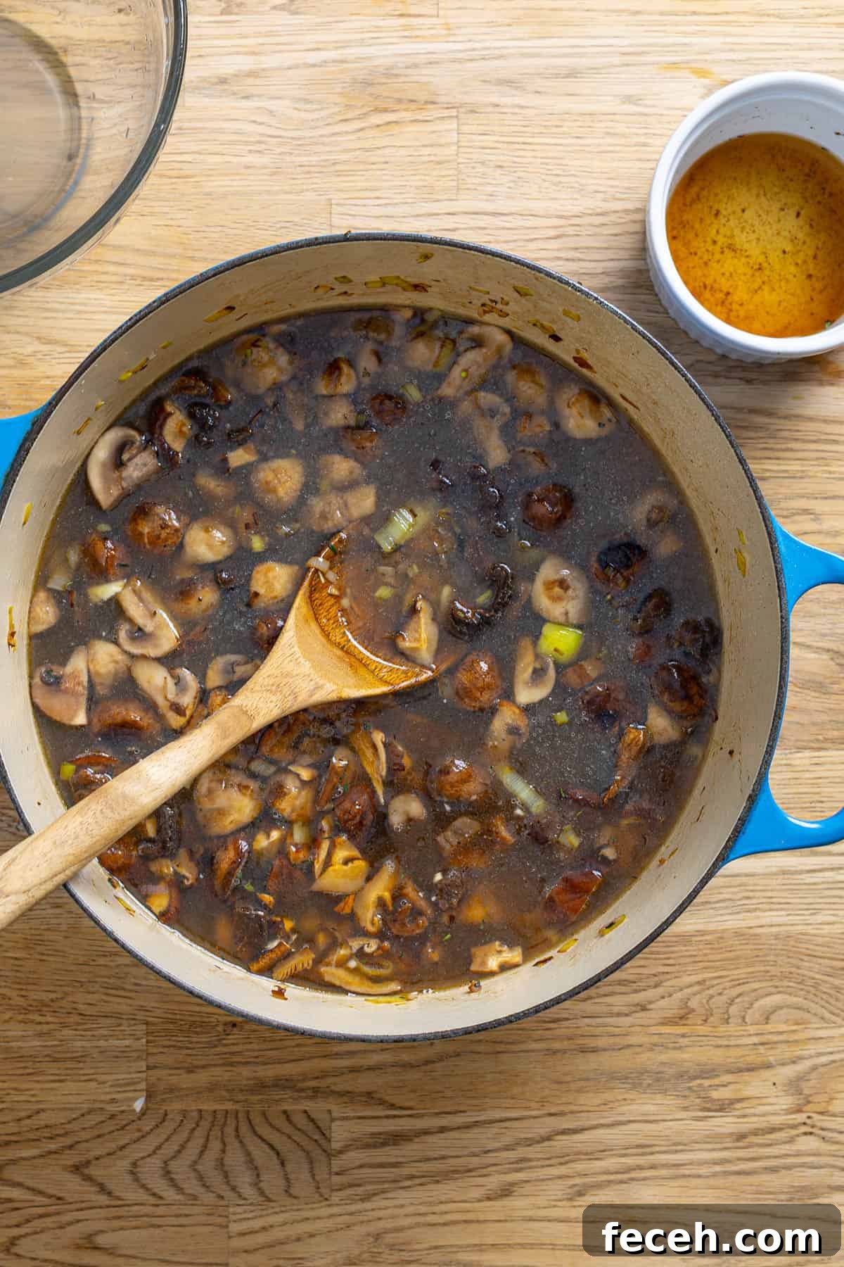 A pot of mushroom and leek soup cooking.