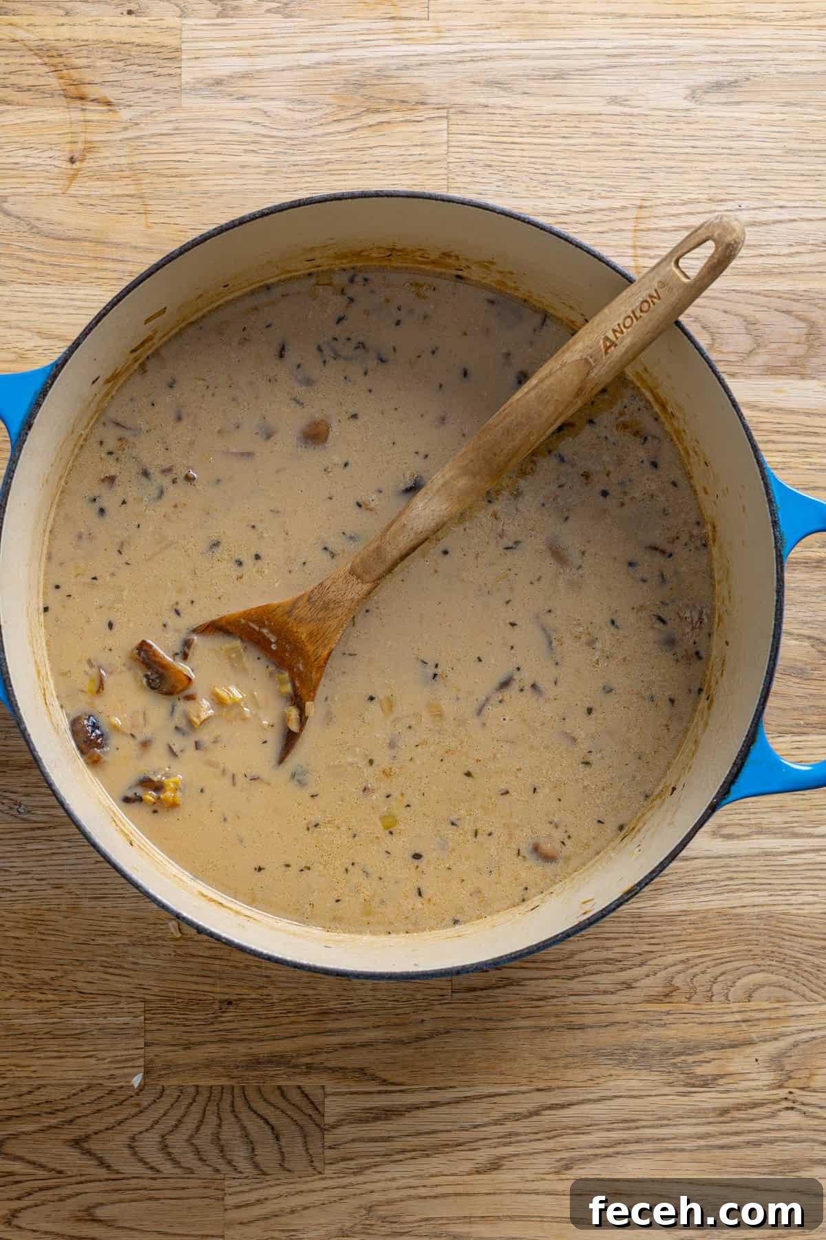  A dutch oven with mushroom leek soup on a butcher block counter.