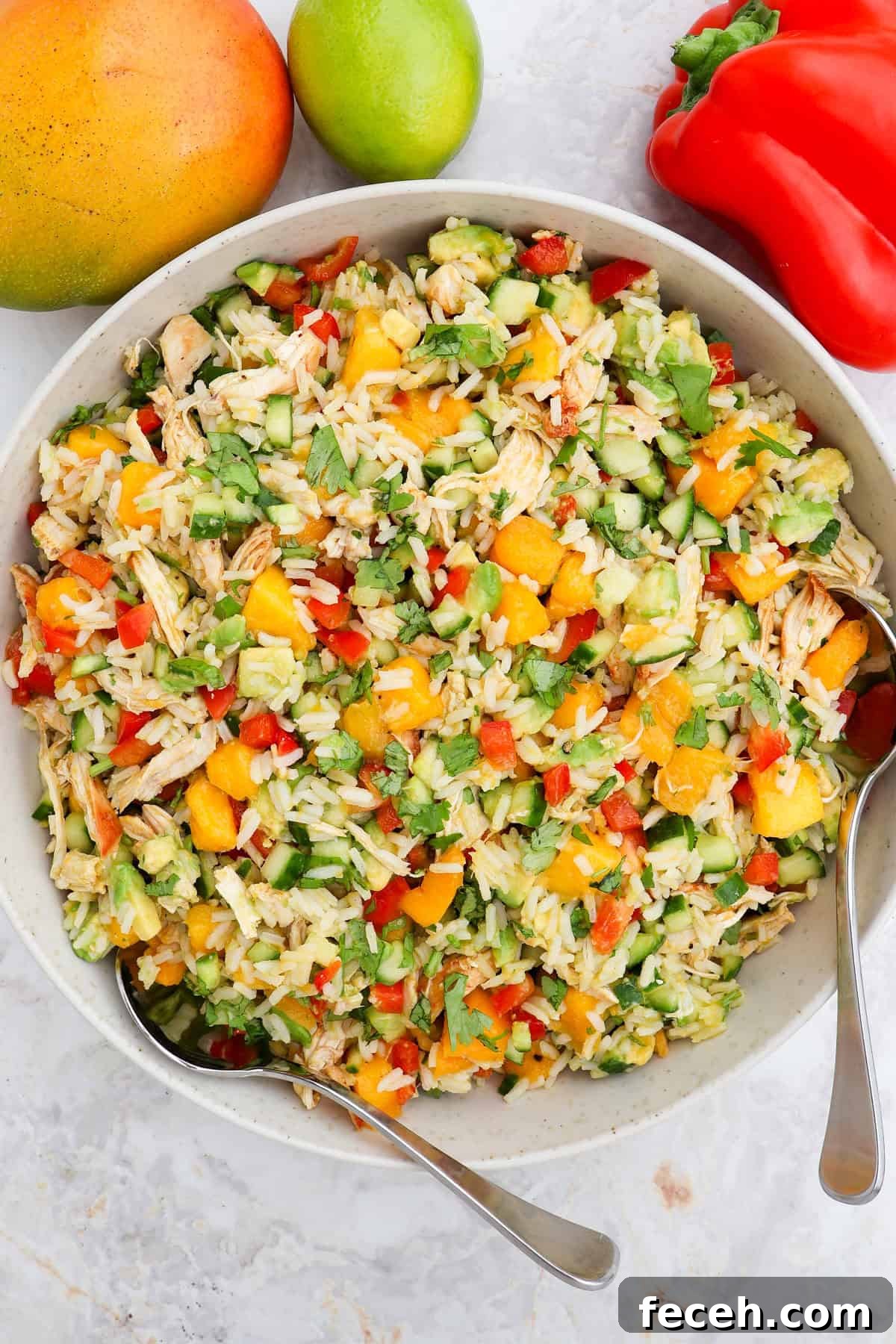 Mango salad served in a bowl with spoons.