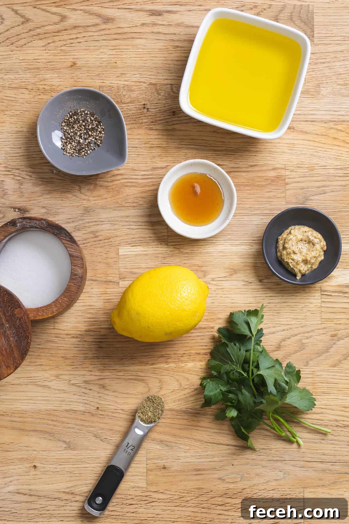 Ingredients for lemon Dijon dressing on a butcherblock countertop.