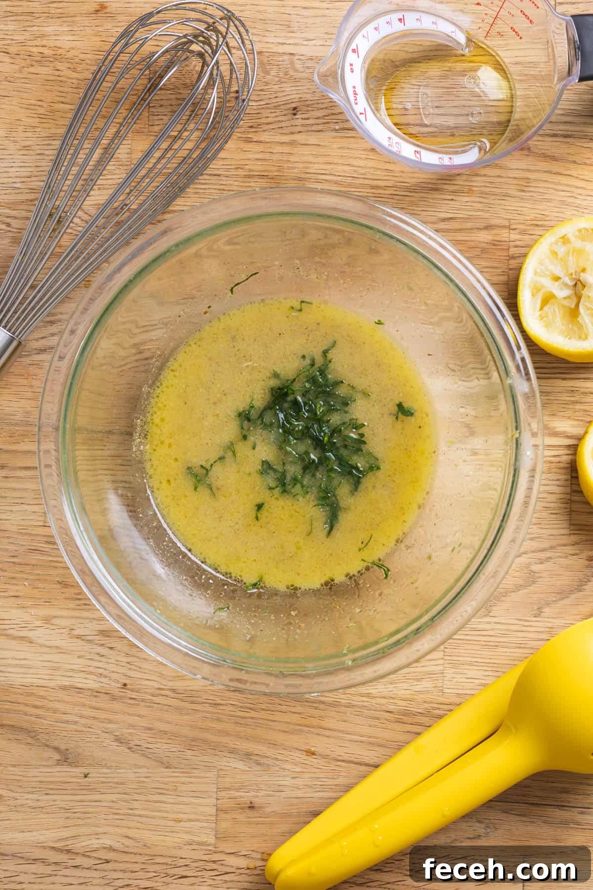 Chopped parley in a glass bowl of lemon Dijon dressing.