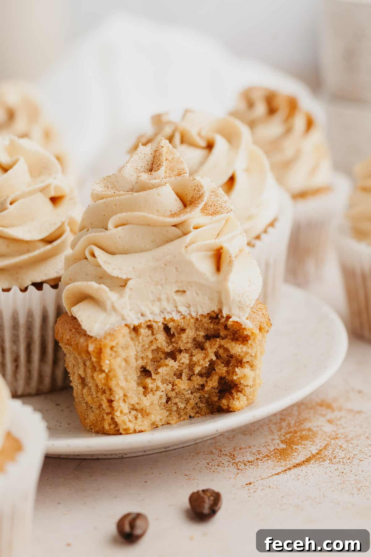 A close up of a coffee cupcake with a bite taken out of it.