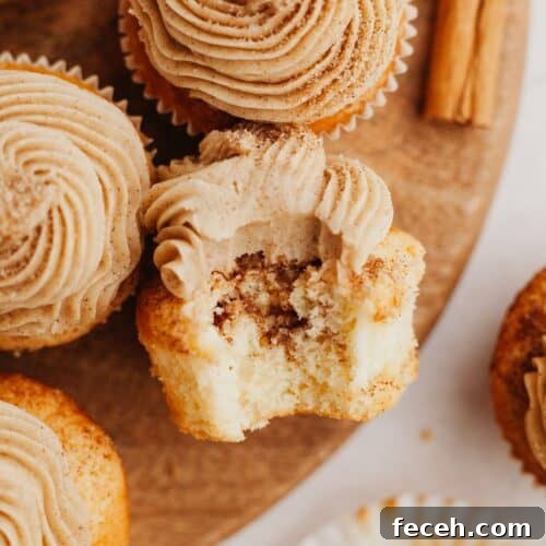 A cinnamon cupcake with a bite taken out of it.