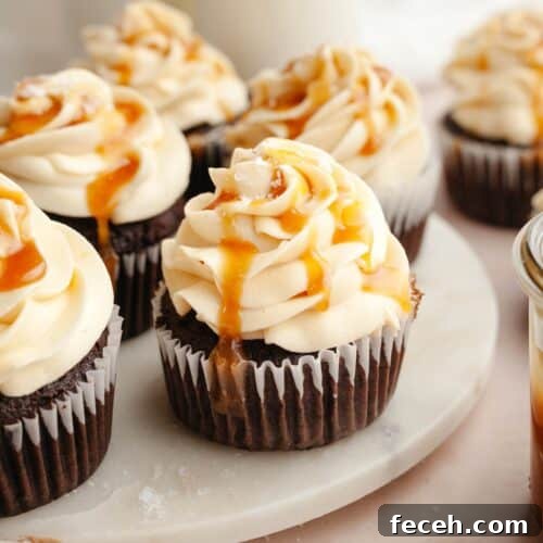 Chocolate cupcakes with caramel buttercream on white marble.
