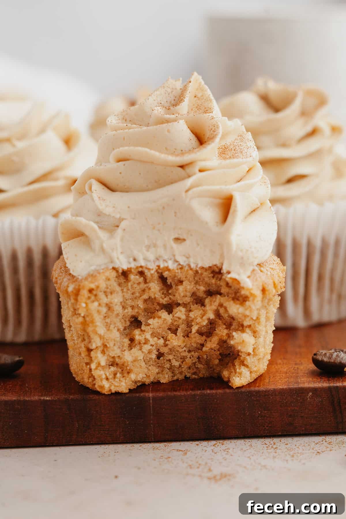 A close up of an espresso cupcake with a bite taken out of it.