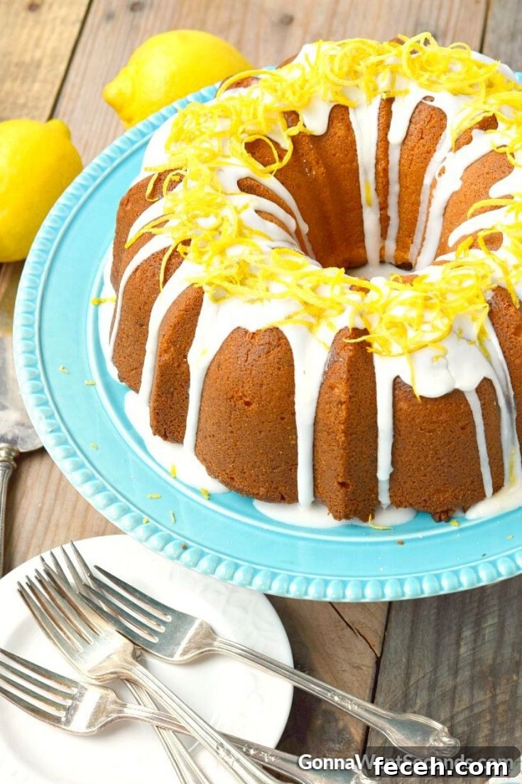 Lemon cream cheese pound cake is a moist decadent springtime treat covered in a sweet lemon glaze that offers a little sunshine in every bite. #poundcake #lemoncake Lemon cream cheese pound cake on a cake stand
