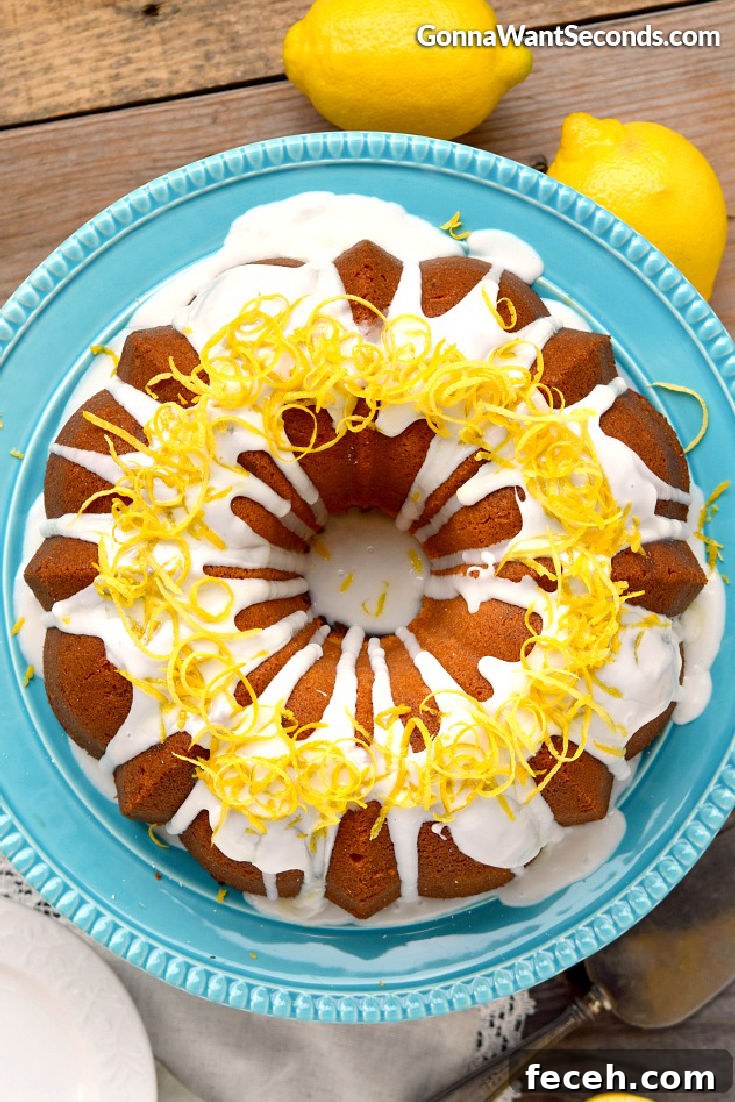 Lemon cream cheese pound cake is a moist decadent springtime treat covered in a sweet lemon glaze that offers a little sunshine in every bite. #poundcake #lemoncake lemon pound cake with cream cheese on a cake stand