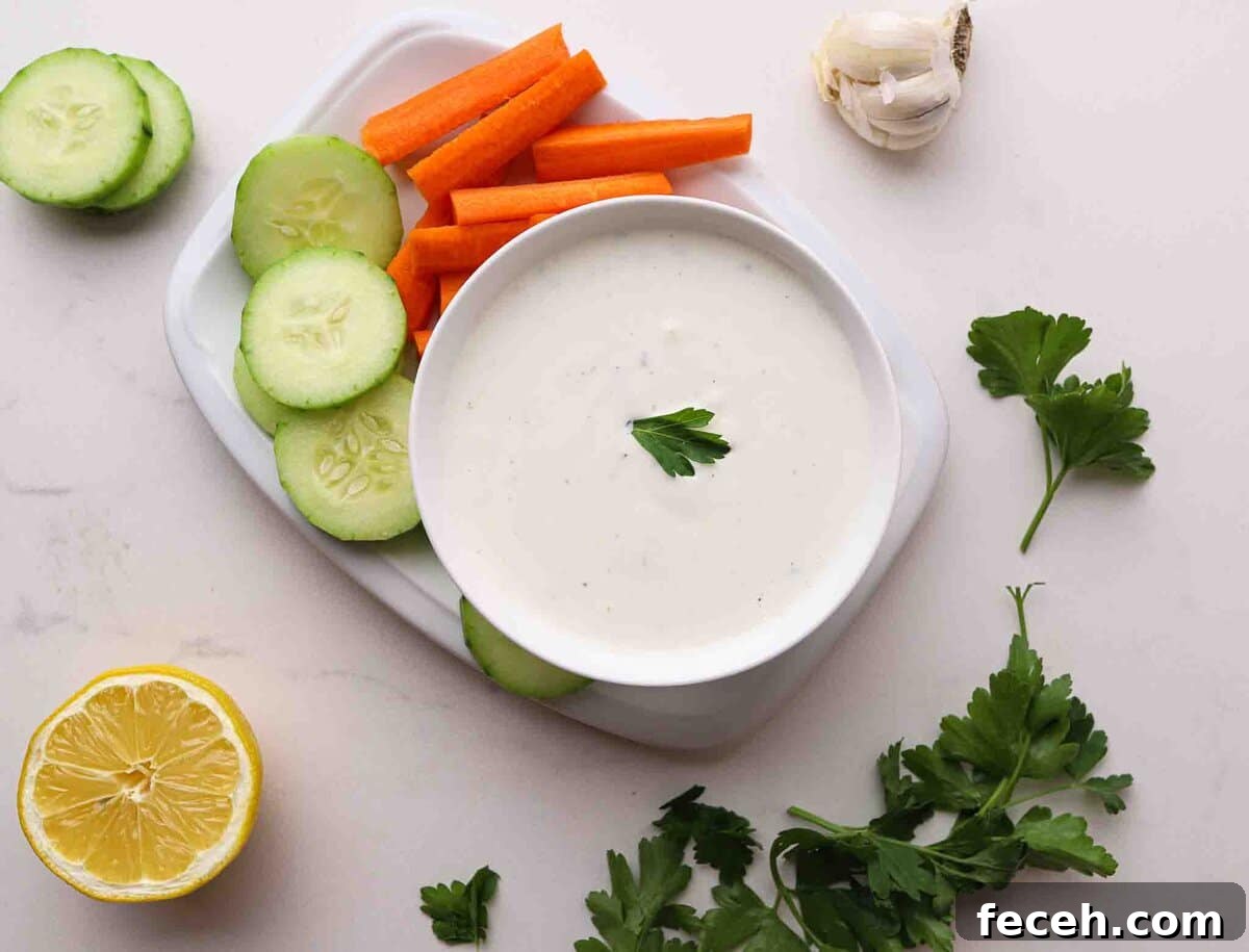 Quick Greek Yogurt Ranch Dip Ready in 5 Minutes 5 Bowl of ranch dressing surrounded by carrots and cucumbers.