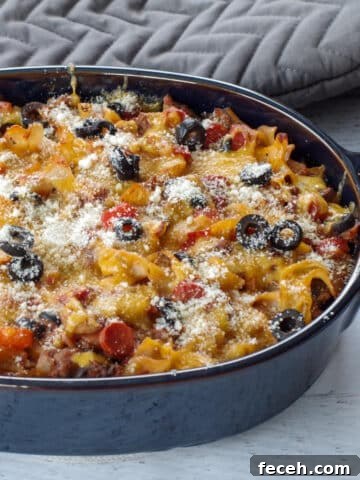 healthy pizza casserole in a blue casserole dish with grey oven mitts in the background