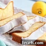 slices of gluten free lemon loaf cake on white rectangular platter with whole lemons in the background.