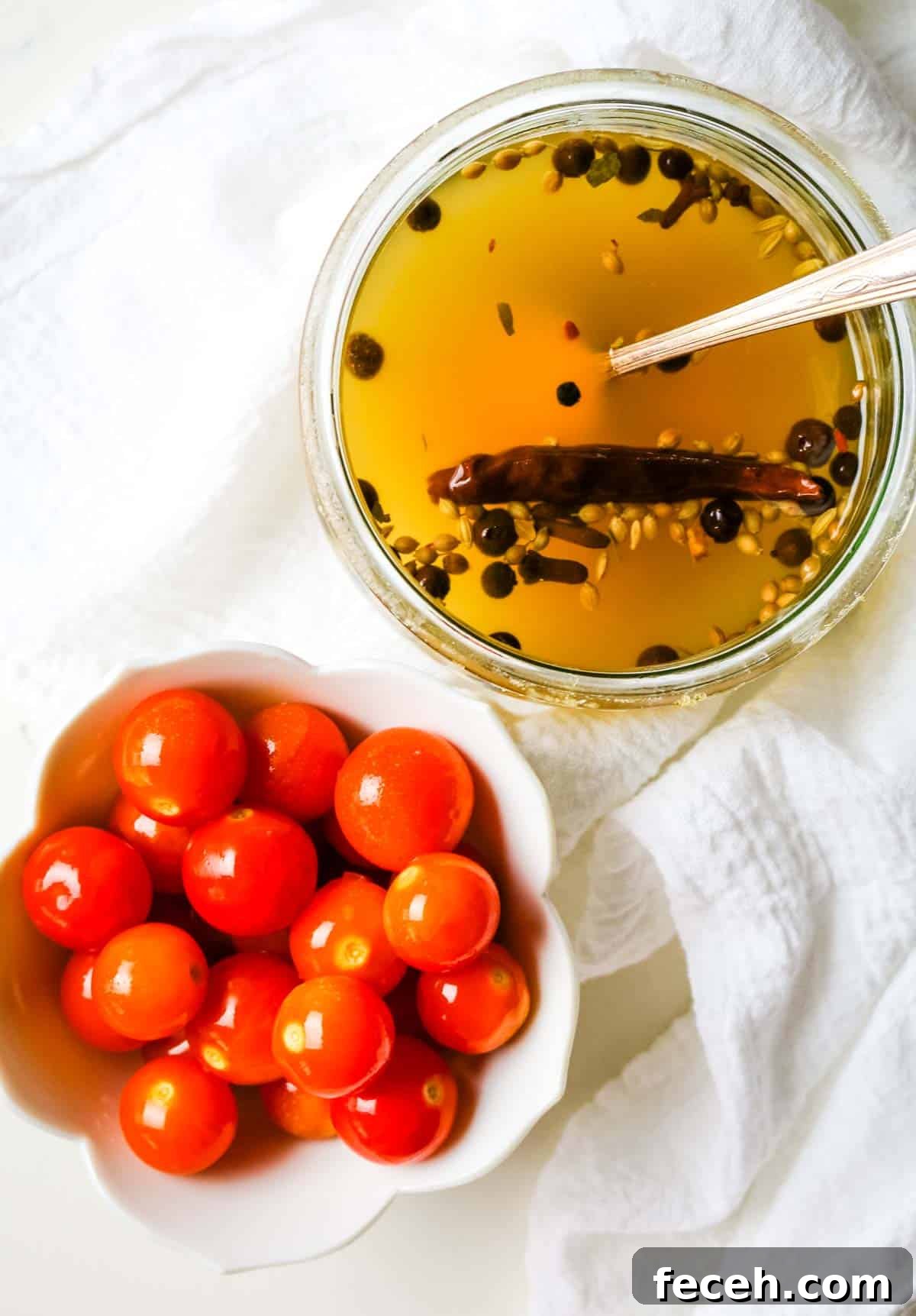 cherry tomatoes in a small white dish with brine in jar.