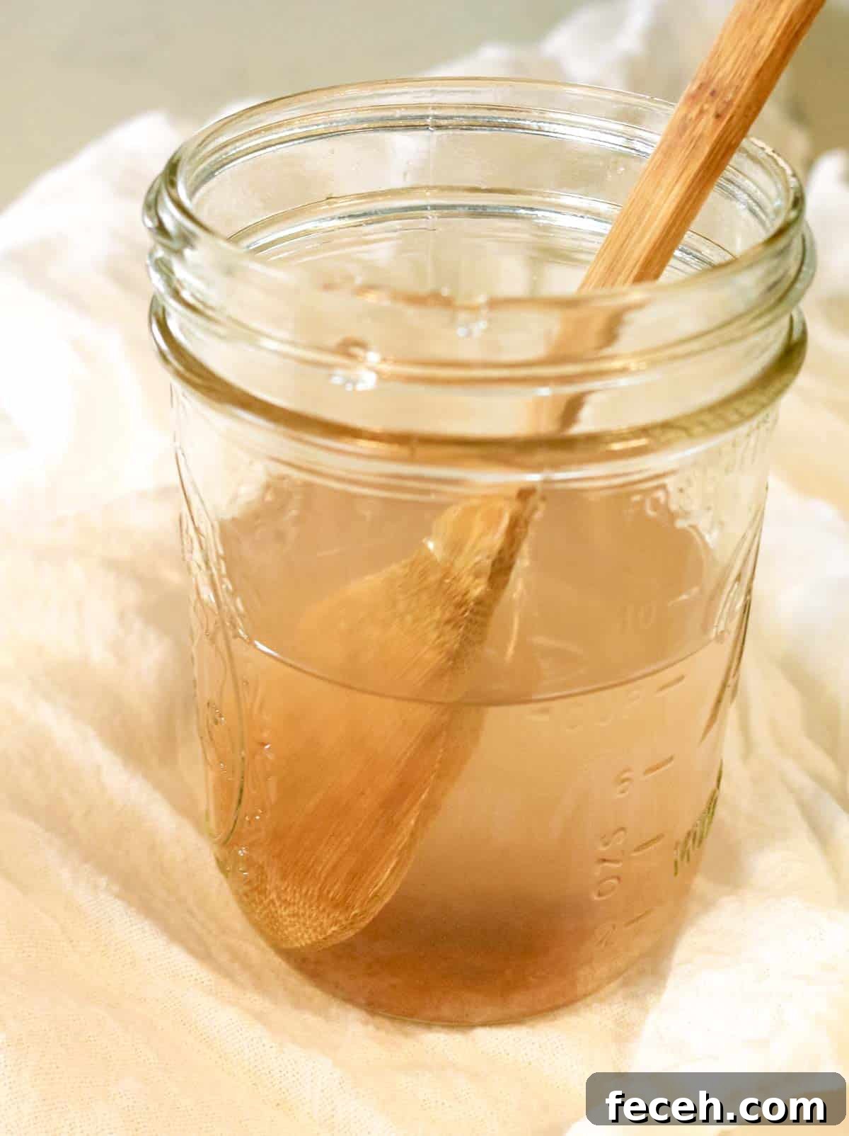 mason jar with salty brine and wooden spoon.