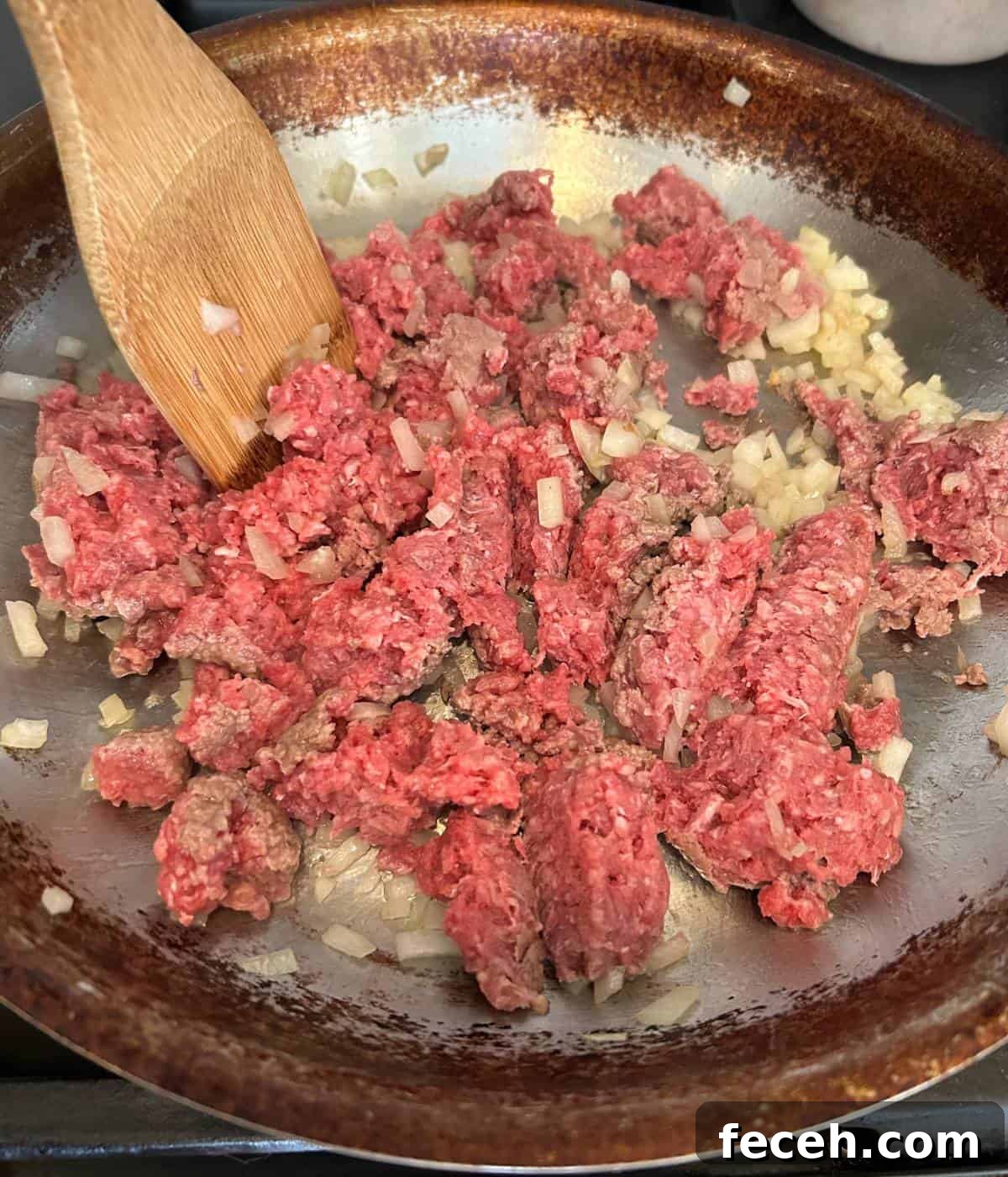 Hawaiian Roll Cheeseburger Sliders Recipe for Party Appetizers 5 Ground beef and onions cooking in pan with wooden spoon breaking up the meat.