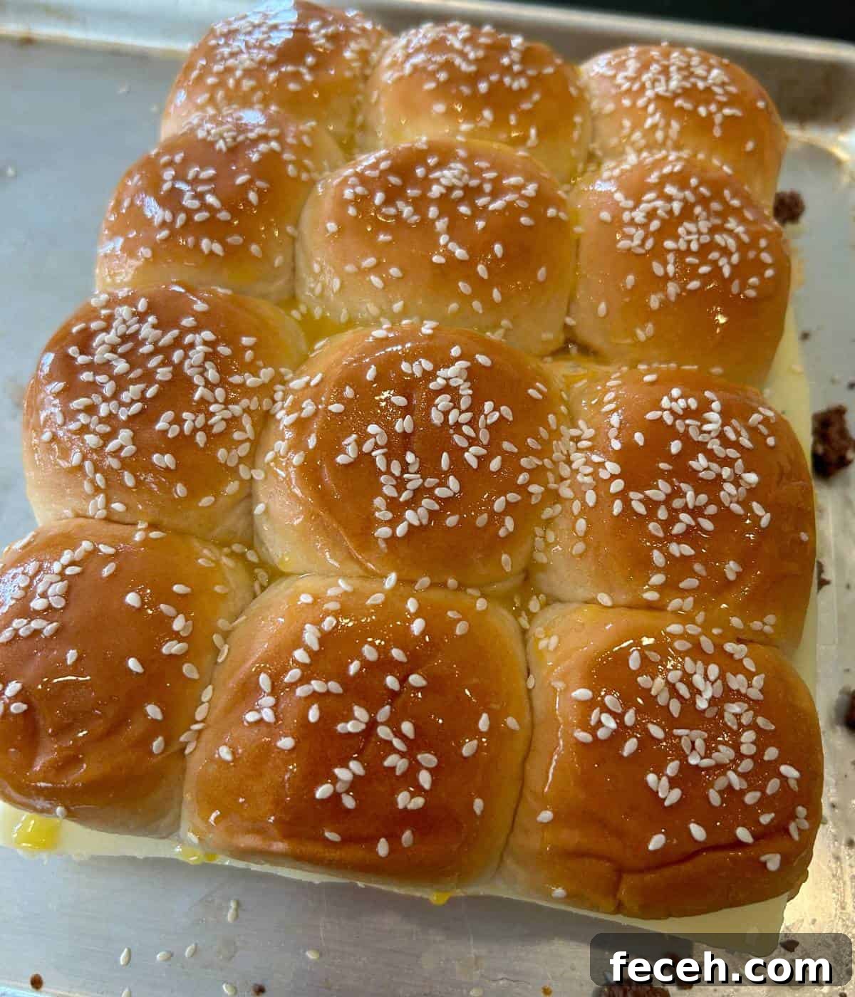 Hawaiian Roll Cheeseburger Sliders Recipe for Party Appetizers 9 Hawaiian rolls topped with melted butter and sesame seeds.