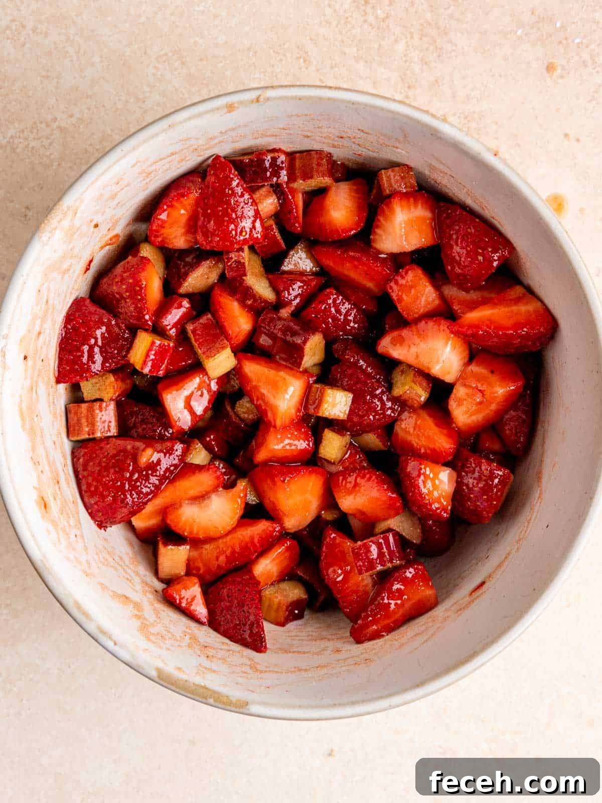 Chopped strawberries, rhubarb, brown sugar, cornstarch and lemon juice mixed in a bowl.