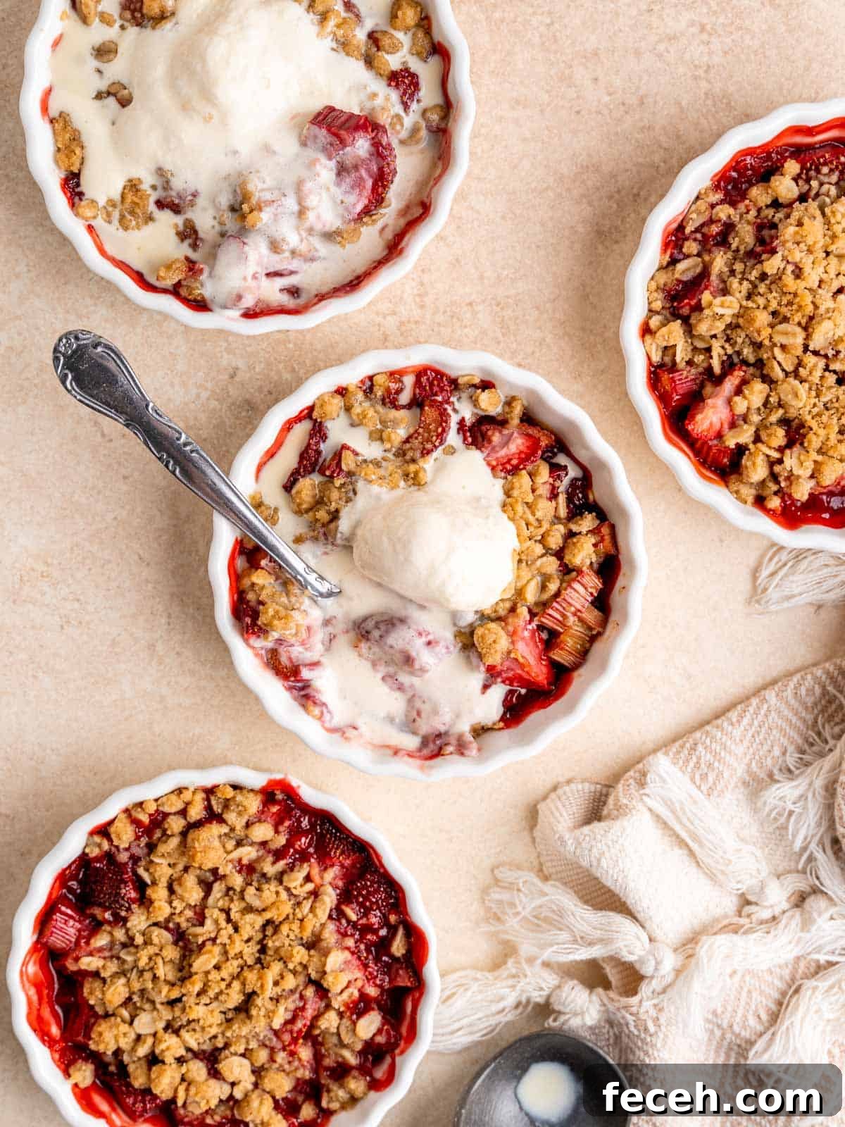 Top view of strawberry rhubarb crisps with ice cream.