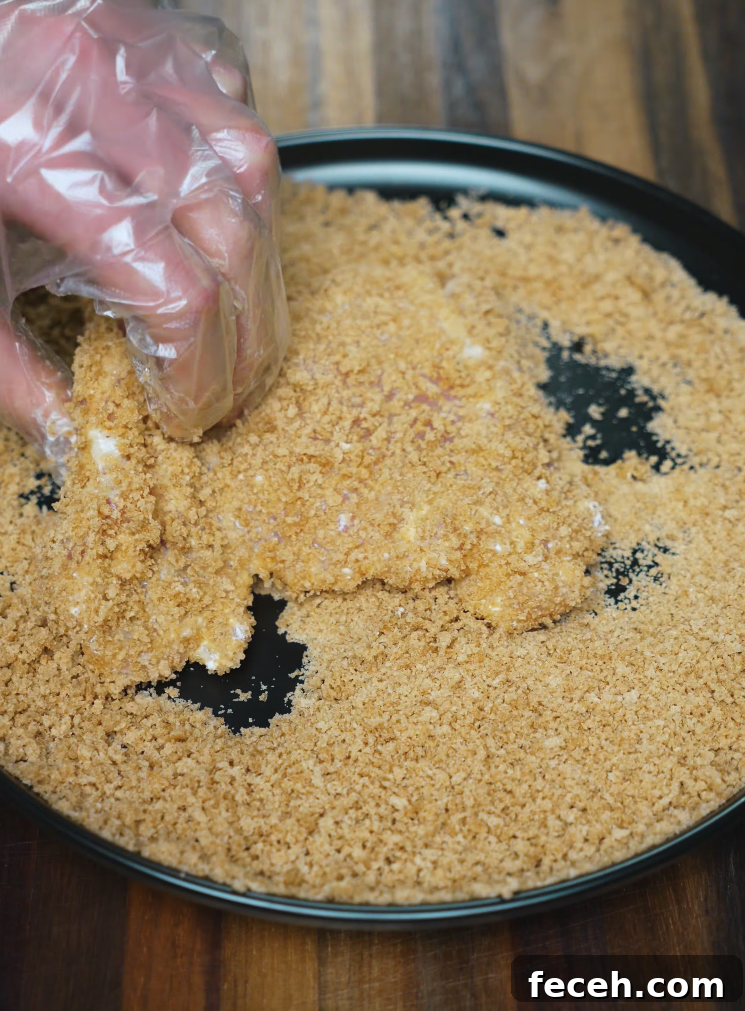 Japanese Chicken Katsu Curry Recipe: Crispy Cutlet with Savory Sauce 4 Boneless chicken thigh being coated in golden panko breadcrumbs for crispy chicken katsu – essential step for homemade chicken katsu curry.