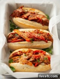 Sausage and Peppers Sandwich 3 sandwiches in large dish with white parchment paper