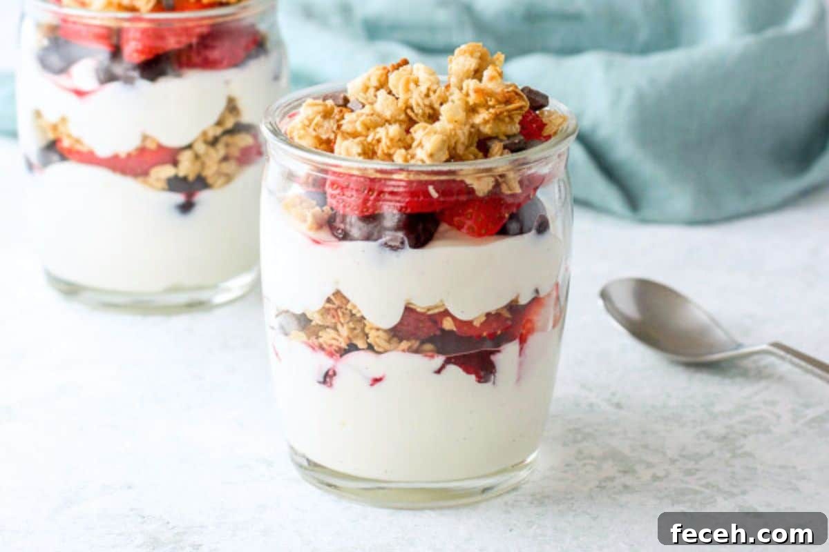Two glass jars with layered yogurt, fruit, and granola - horizontal