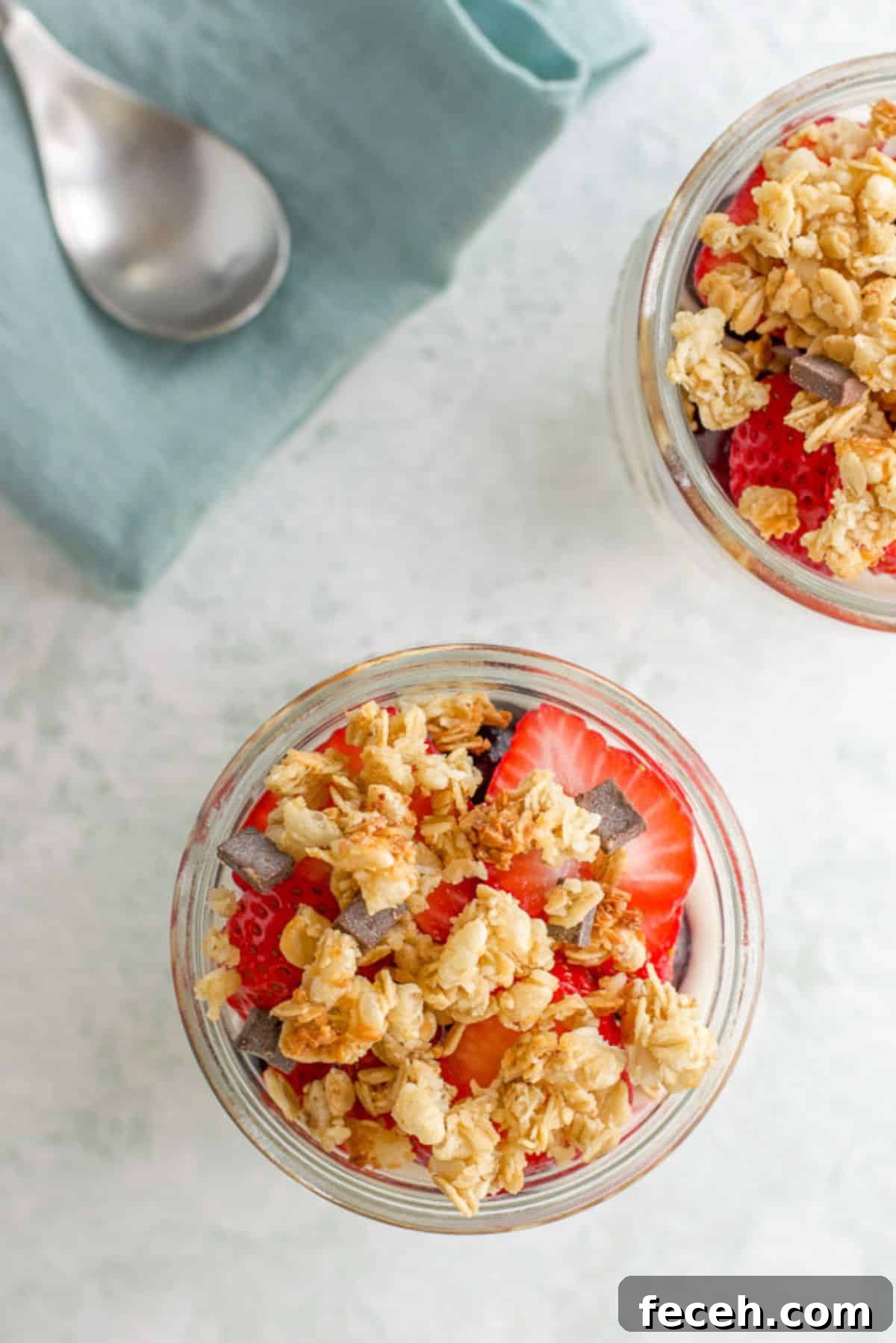 Overhead view of the granola and strawberries on the parfait, with a spoon and napkin