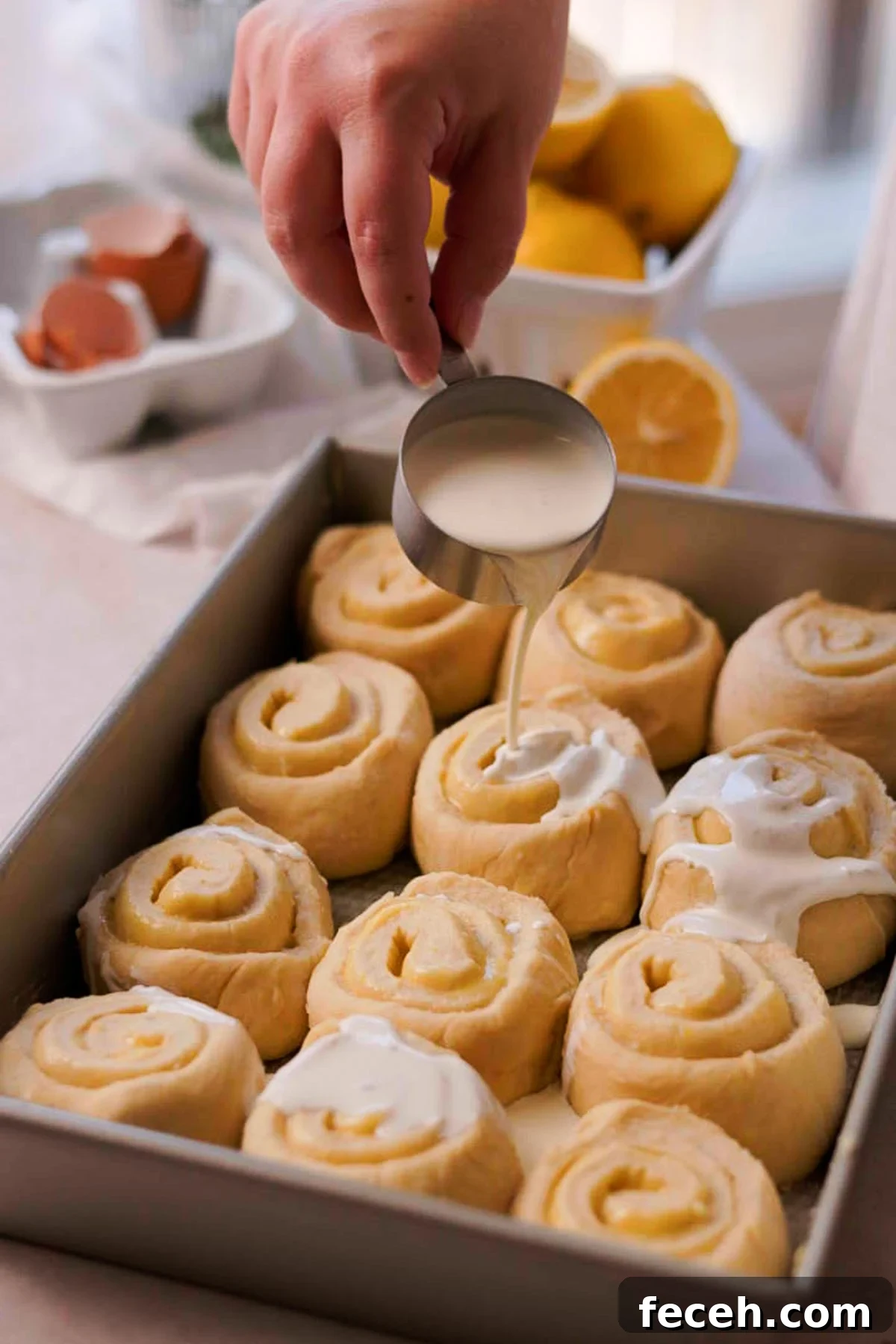pouring cream over the lemon rolls before baking