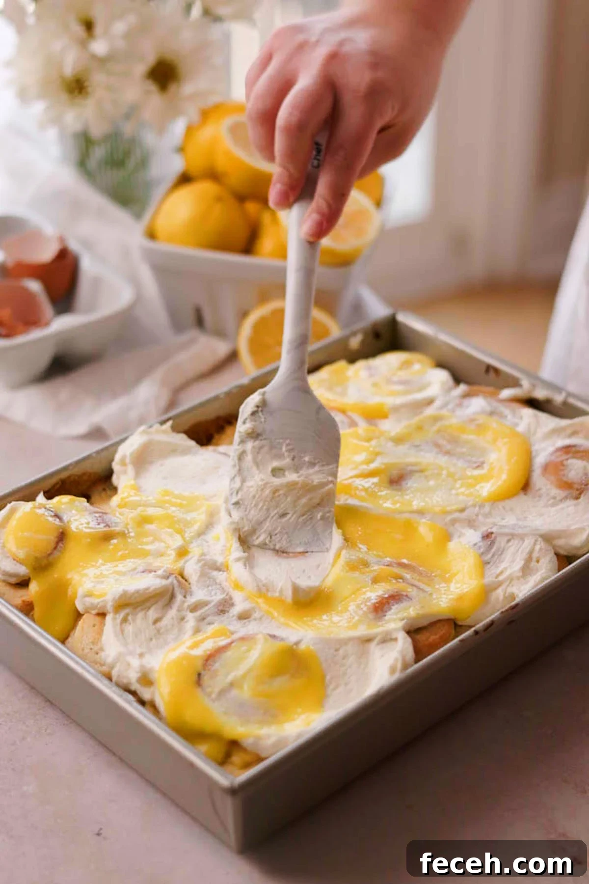swirling frosting with lemon curd on top of lemon rolls