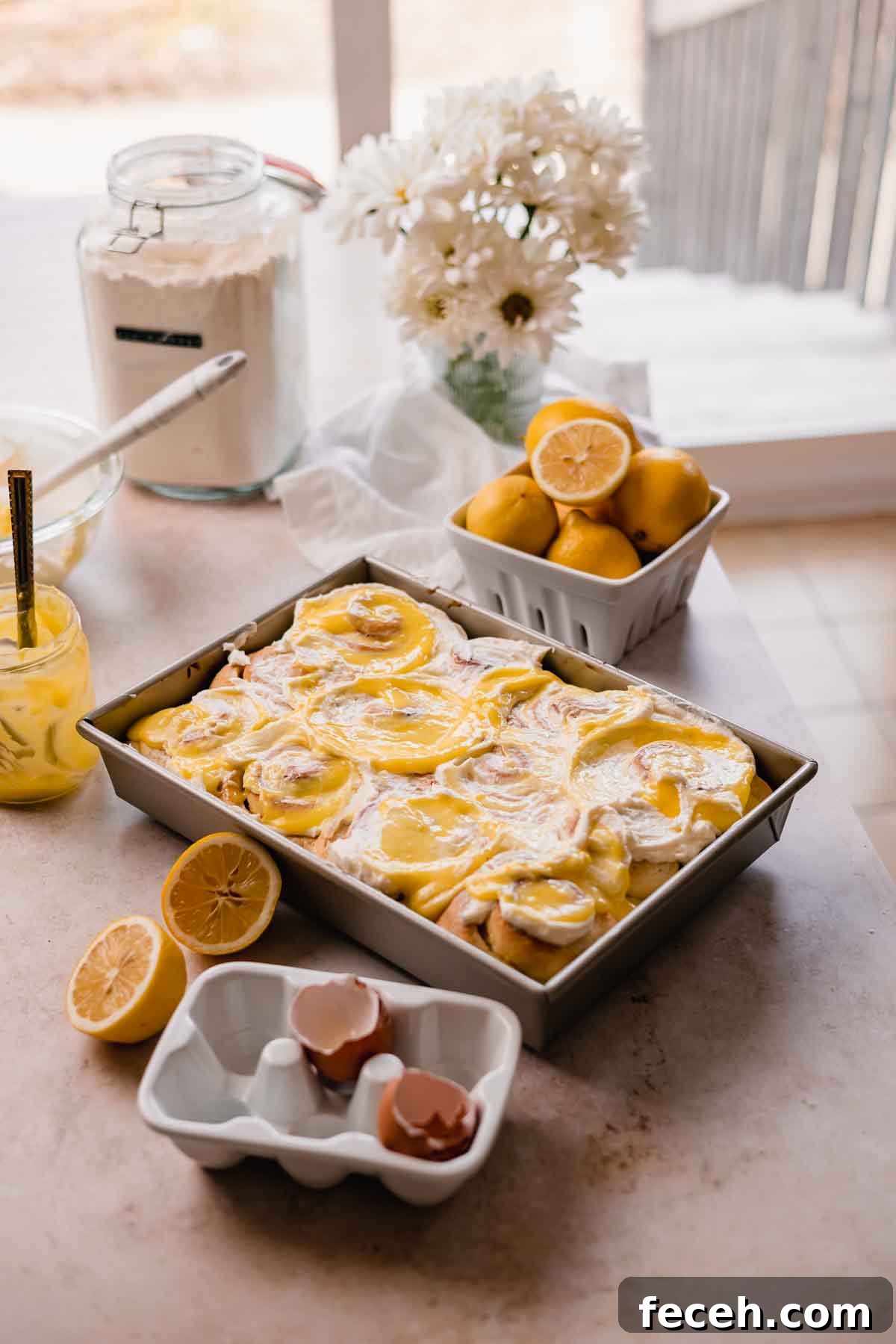 lemon rolls on countertop with flowers and lemons
