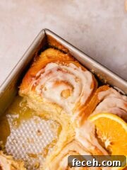 tray of orange cinnamon rolls with 1 missing