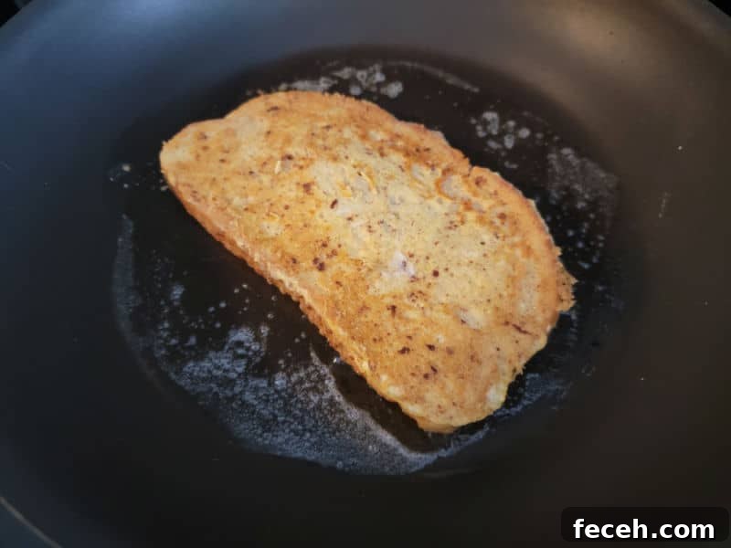 Eggnog French Toast cooking in a pan