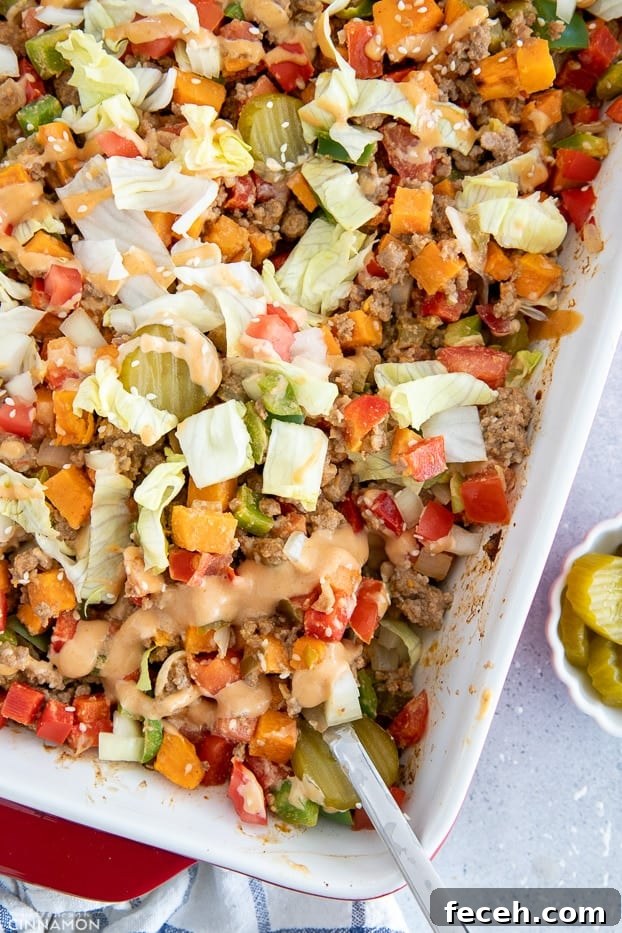 a sliver spoon being stuck into a casserole dish with healthy burger casserole 