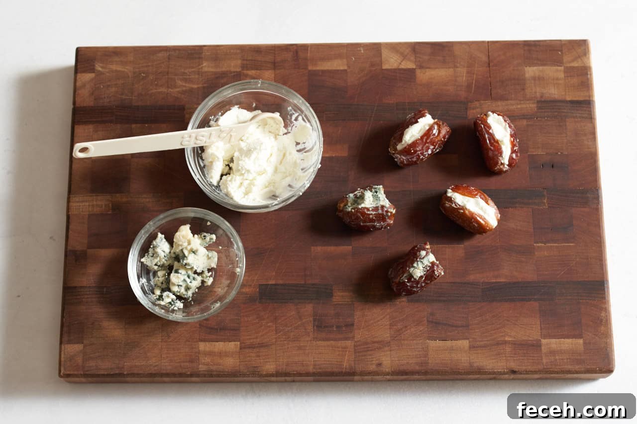 Prosciutto-Wrapped Dates with Goat Cheese and Honey Drizzle 5 Dates stuffed with goat cheese and blue cheese on a cutting board next to small bowls of cheese.