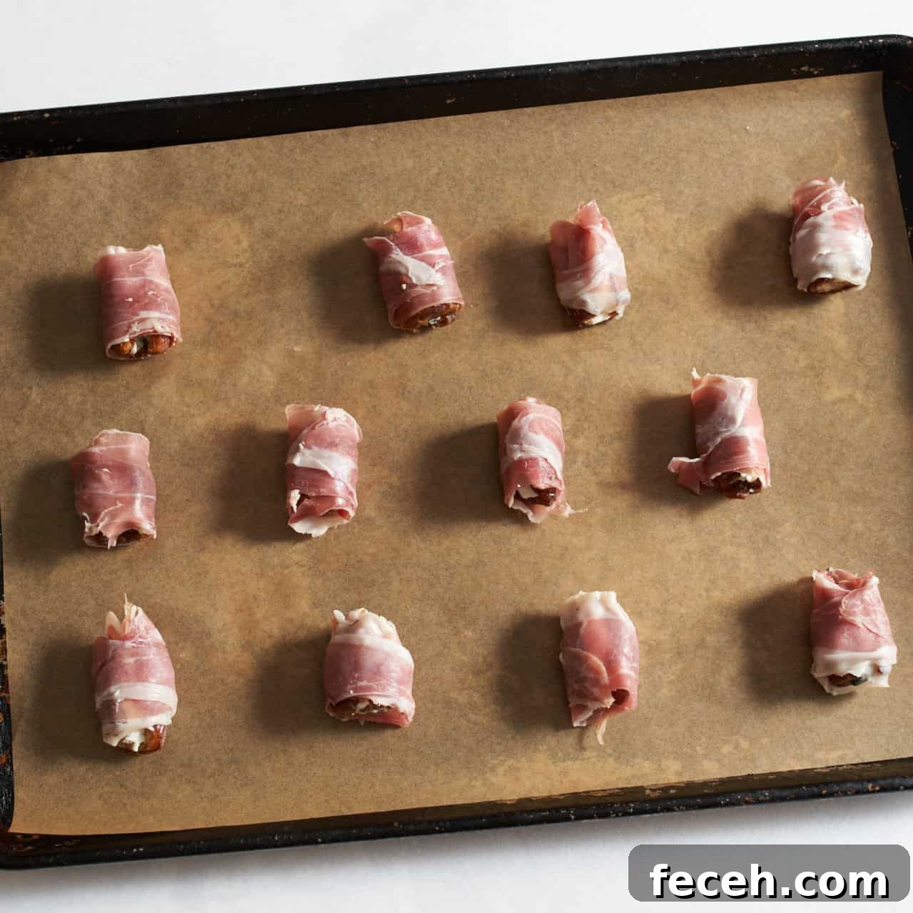 Prosciutto-Wrapped Dates with Goat Cheese and Honey Drizzle 6 Prosciutto wrapped dates stuffed with goat cheese and blue cheese on a parchment lined sheet pan.