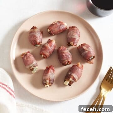 Prosciutto-Wrapped Dates with Goat Cheese and Honey Drizzle 9 Prosciutto wrapped dates stuffed with goat cheese on a pink plate, gold forks and a glass of red wine are on the right.