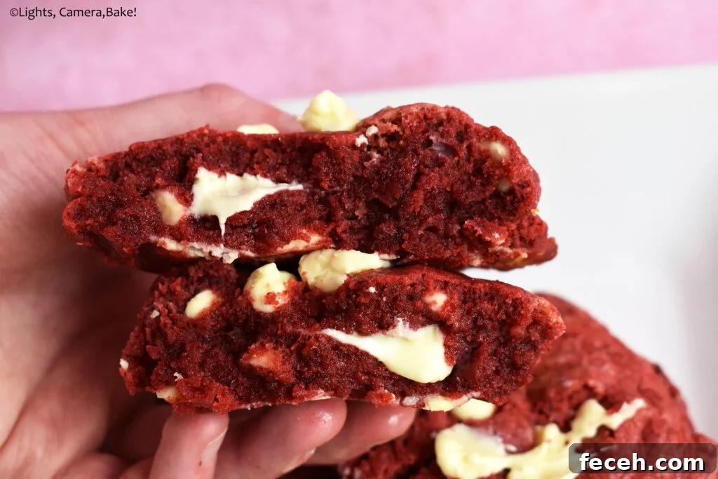 Bakery style red velvet cookie split in half.