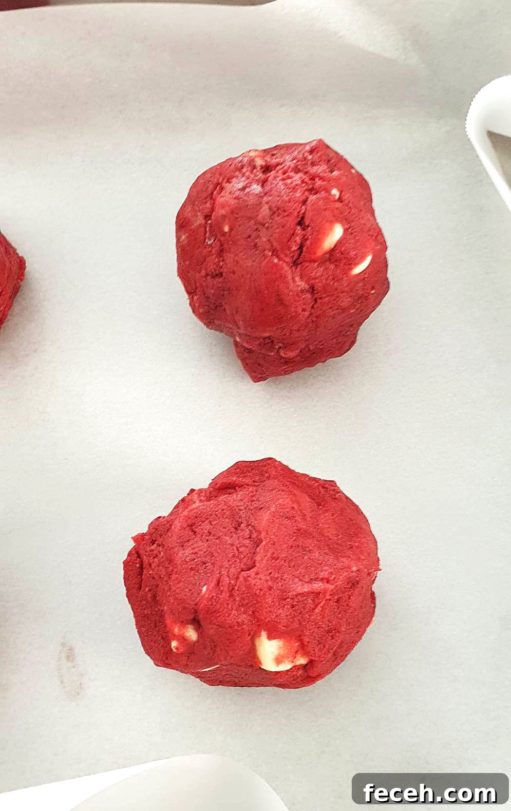 Red velvet cookie dough balls on a tray.