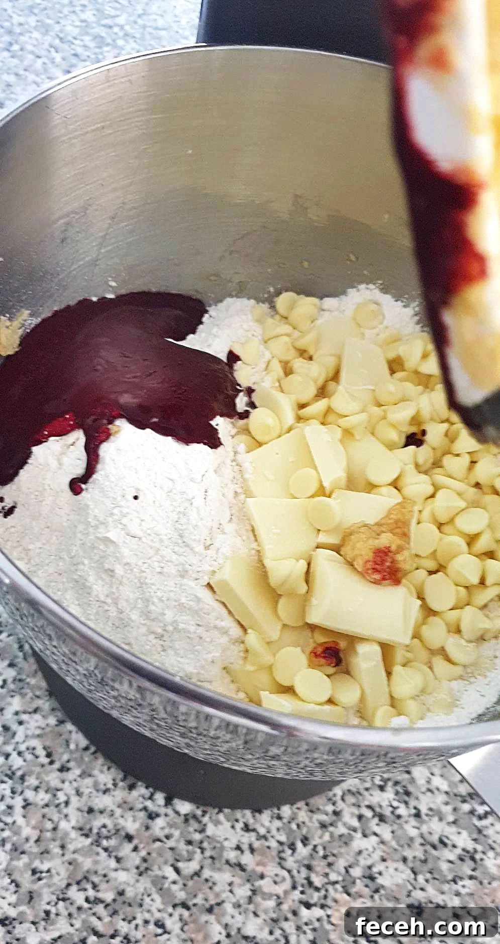 Flour and white chocolate chips added into cookie dough.