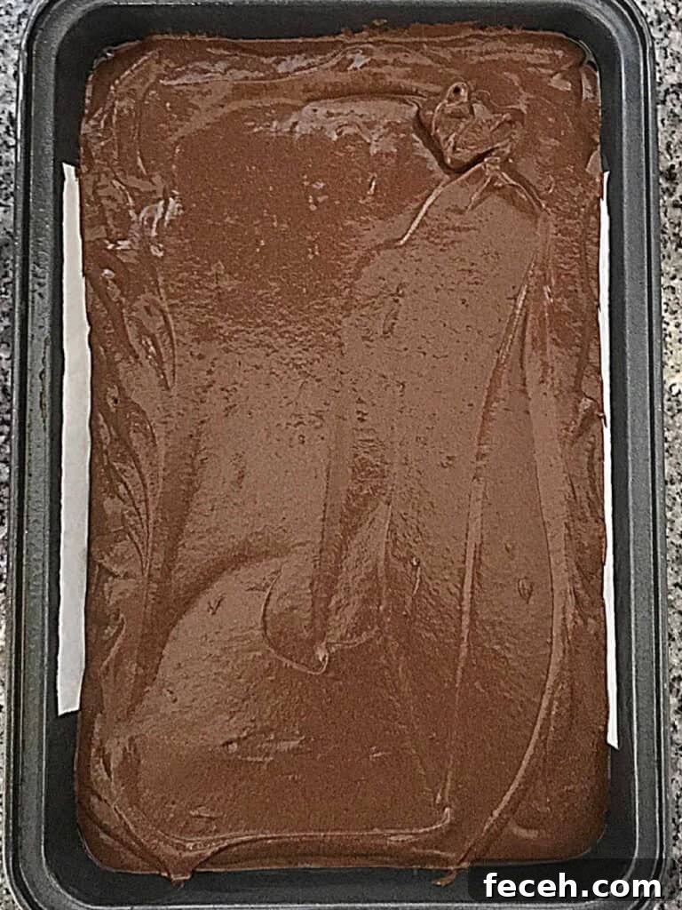 Top view of chocolate cake before baking in a metal rectangular pan.