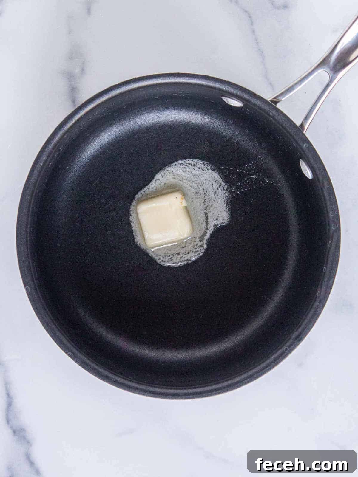 A tablespoon of butter melting in a medium saucepan.