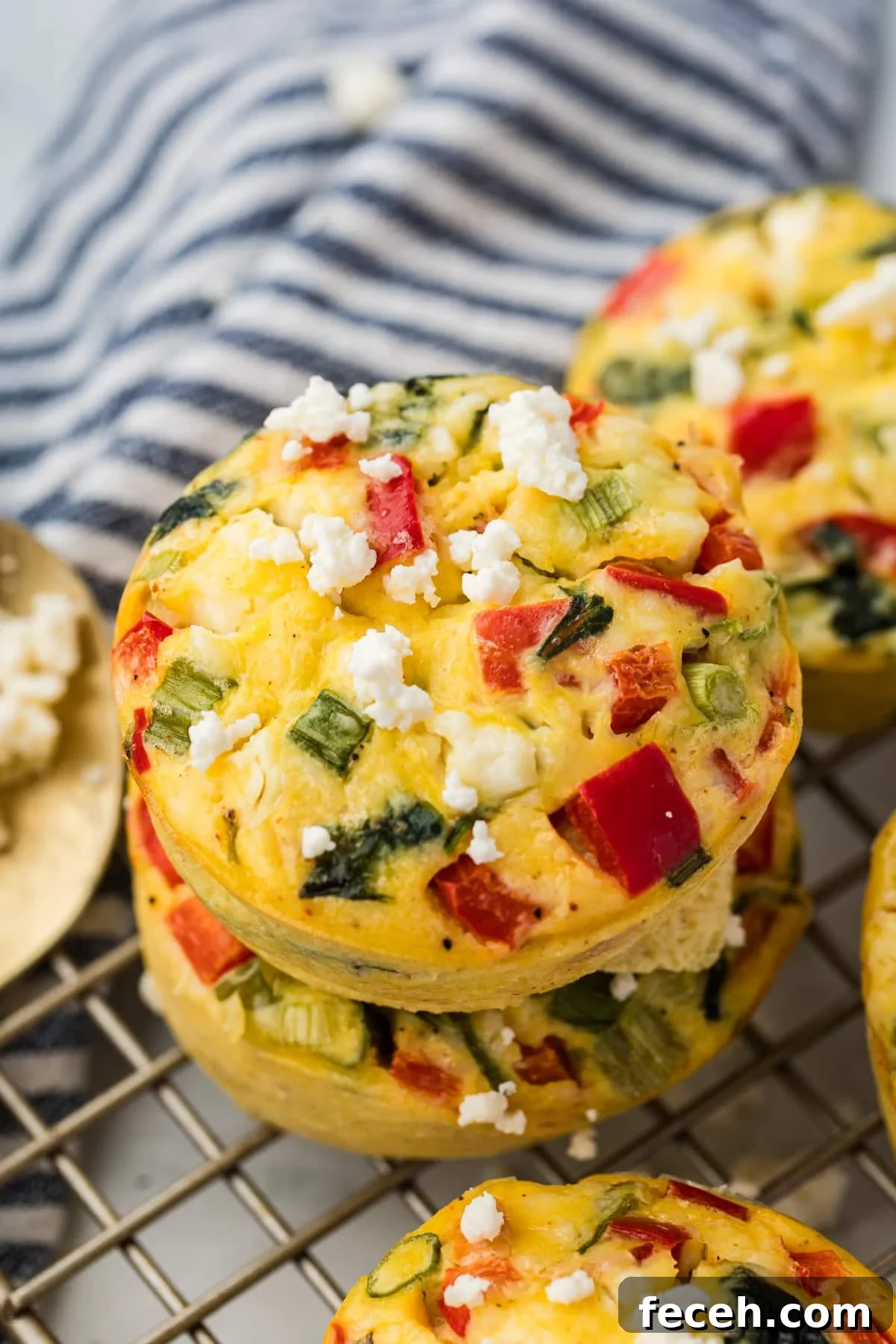 Mini Spinach and Feta Frittatas Recipe 8 Two spinach egg bites stacked on a wire rack.