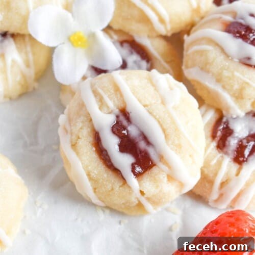 strawberry cookie leaning against pile of shortbread cookies.